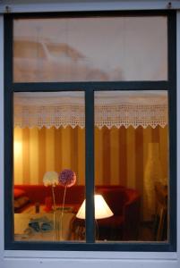 a window view of a living room with a table at Ferienwohnung Nachbars Garten in Grünendeich