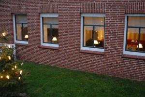 a brick building with a christmas tree in the grass at Ferienwohnung Nachbars Garten in Grünendeich