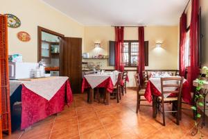 a restaurant with tables and chairs with red curtains at Bed and Breakfast San Domenico in Realmonte