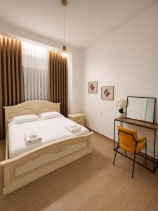 a bedroom with a bed and a chair in it at Friends Home in Tirana