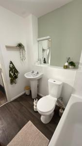 a bathroom with a white toilet and a sink at Sheffield city centre apartment in Midland