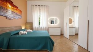 a bedroom with a green bed with two towels at Villa Natina in Pizzo