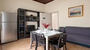 a dining room with a table with chairs and a refrigerator at Villa Natina in Pizzo