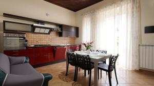a kitchen with red cabinets and a table with chairs at Villa Natina in Pizzo