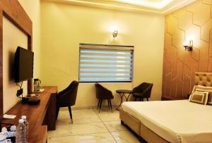 a bedroom with a bed and a desk and a television at Shakti Resort in Behror