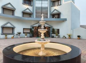 a fountain in front of a building at Shakti Resort in Behror