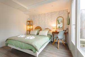 a bedroom with a bed and a desk and a mirror at Chambre d'hôtes La Beunaise in Rochefort
