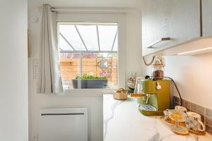 a kitchen with a counter top with a window at Chambre d'hôtes La Beunaise in Rochefort