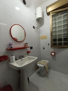 a bathroom with a sink and a toilet and a mirror at Villa Maria in Campobello di Mazara +39 photos