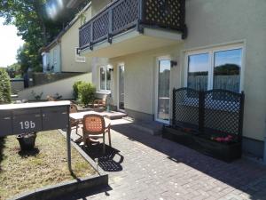 a house with a patio with a table and a balcony at Brandt Ferienwohnungen Jägersberg in Ahlbeck