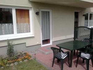 a patio with a table and chairs in front of a house at Brandt Ferienwohnungen Jägersberg in Ahlbeck +21 photos