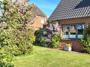 a brick house with a flowering tree in the yard at Hook in Midlum