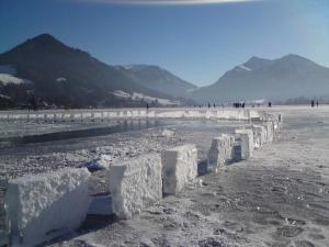 a group of ice blocks on a beach with mountains in the background at Landhaus SeenSucht in Schliersee