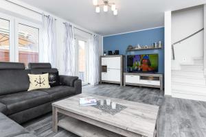 a living room with a couch and a tv at Ferienhaus Ella in Dornumersiel