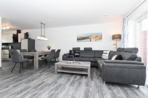 a living room with a couch and a table at Ferienhaus Ella in Dornumersiel