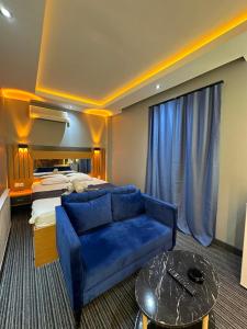 a hotel room with a blue couch and a bed at tuzla first house in Tuzla