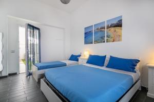 a bedroom with two beds with blue pillows at Le Camere Di Anna in Gallipoli