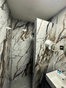 a bathroom with a sink and a marble wall at tuzla first house in Tuzla +57 photos