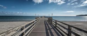 a wooden boardwalk leading to the ocean on a beach at Fewo`s Mehlberg Binz in Binz