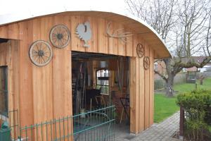 a wooden building with an open door in a yard at Grischow Ferienwohnung in Grischow