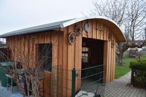 a small wooden building with a black roof at Grischow Ferienwohnung in Grischow