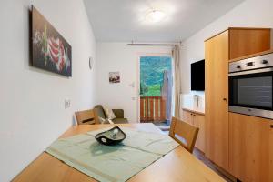 a kitchen and dining room with a table and a television at Residence Sonngart in Lagundo