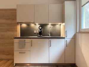 a kitchen with white cabinets and a sink at Siegelsbacher Muehle in Siegelsbach