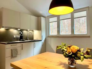a kitchen with a wooden table with a vase of flowers at Siegelsbacher Muehle in Siegelsbach