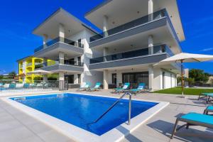 a villa with a swimming pool in front of a building at Apartments Luna in Malinska