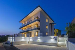 a large white building with lights on at Apartments Luna in Malinska
