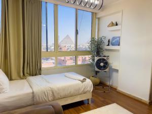 a bedroom with a bed and a large window at luxurios hotel with pyramids view in Cairo