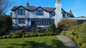 ein großes weißes Haus mit einem Schornstein in der Unterkunft Scourie Hotel in Scourie