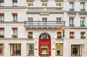 a red brick building with a red door and windows at Hôtel Beauchamps in Paris