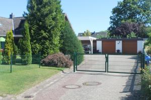 a gate in a yard with a house at Thiessen - Ferienwohnung mit sonnigem Balkon in Silberstedt
