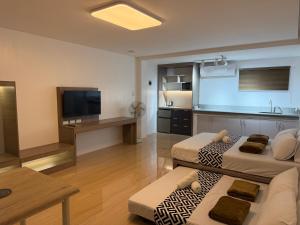 a living room with two beds and a kitchen at Amado's Transient Inn - Free Wide Parking Space in Prado