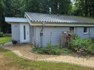 a small house with a fence in a yard at Ferienhaus Paulsen - gemütliches Häuschen mit vollständig eingezäuntem Garten und Kamin in Silberstedt