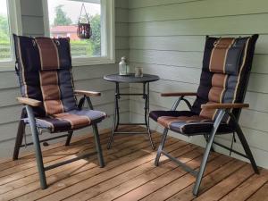 two chairs and a table on a porch at Ferienhaus Paulsen - gemütliches Häuschen mit vollständig eingezäuntem Garten und Kamin in Silberstedt +34 photos