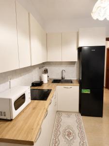 a kitchen with a black refrigerator and a microwave at Friends Home in Tirana +11 photos