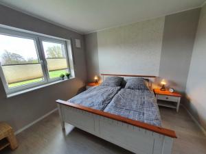 a bedroom with a bed with two lamps on tables at Ferien am Idasee 85041 in Ostrhauderfehn