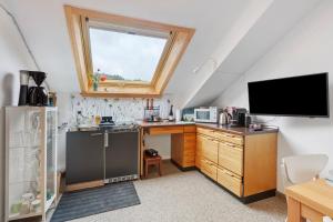a kitchen with a sink and a tv in a attic at Ferienwohnung Black Forest Hideaway in Todtnau