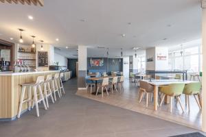 a restaurant with tables and chairs and a bar at Holiday Inn Calais - Centre Car Ferry by IHG in Calais