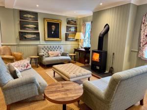 ein Wohnzimmer mit Sofas und einem Holzofen in der Unterkunft Scourie Hotel in Scourie