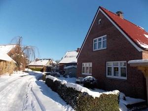 a house is covered in snow on a street at Ferienhaus Dieknuest, 15172 in Leer