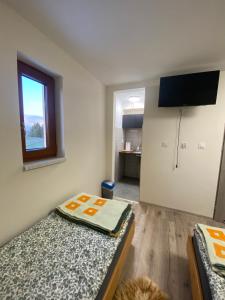 a room with two beds and a television in it at Kapacówka in Zakopane