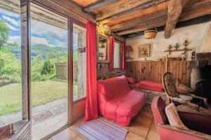 a living room with a red couch and a window at La Barraço in Nalzen