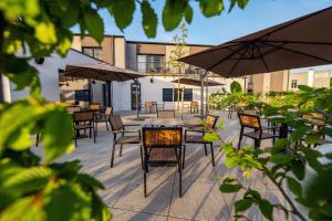 a patio with tables and chairs and umbrellas at Hotel NOBILIS - Mladá Boleslav in Bradlec