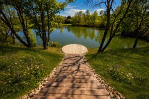 a path leading to a lake with an umbrella at Hotel NOBILIS - Mladá Boleslav in Bradlec