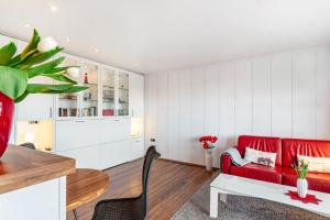 a living room with a red couch and a table at Apartment Korthals 42 in Wangerland +12 photos