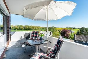 a patio with a table and chairs and an umbrella at Apartment Korthals 42 in Wangerland
