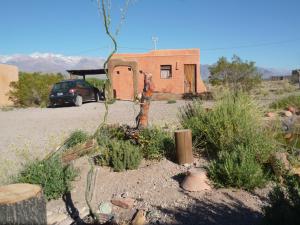 a building in the middle of a desert with a car at Mamuna Casas Loft in Uspallata